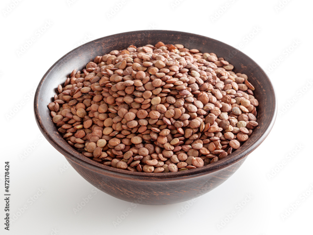 Uncooked lentils in ceramic bowl isolated on white background with clipping path