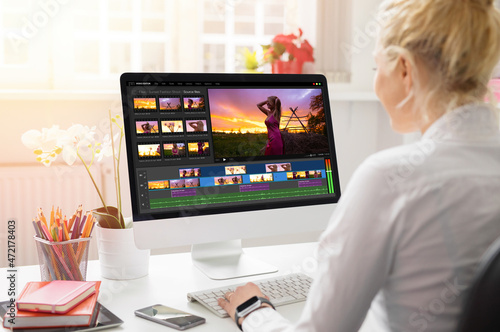 Woman editing video on desktop computer photo