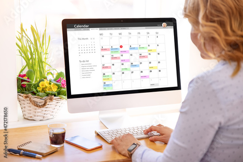 Woman using calendar app on desktop computer