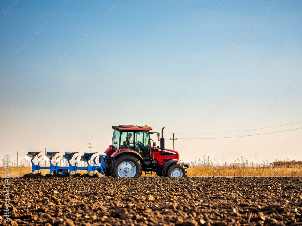 Obraz premium Farmer in tractor plowing preparing stubble field cultivating for seeding crops.