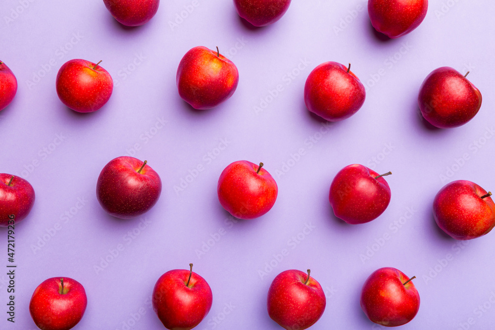 Many red apples on colored background, top view. Autumn pattern with fresh apple above view Many red apples on colored background, top view. Autumn pattern with fresh apple above view