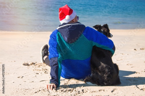 relaxed man at christmas with dog on the beach