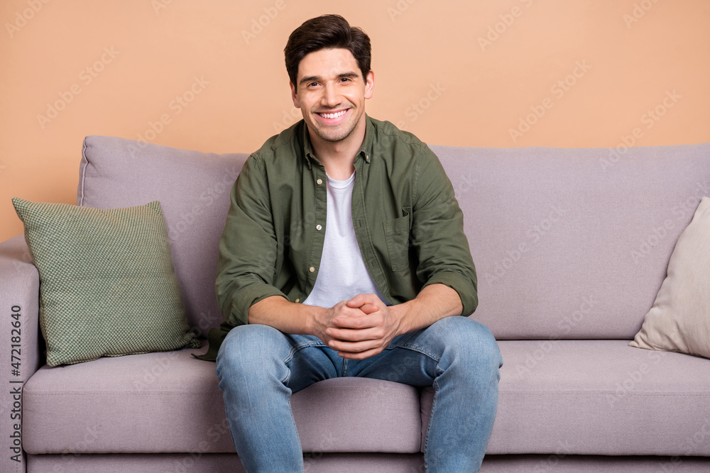 Photo of good mood person sit comfy divan furniture enjoy new house vacation isolated over beige color backround Photo of good mood person sit comfy divan furniture enjoy new house vacation isolated over beige color backround