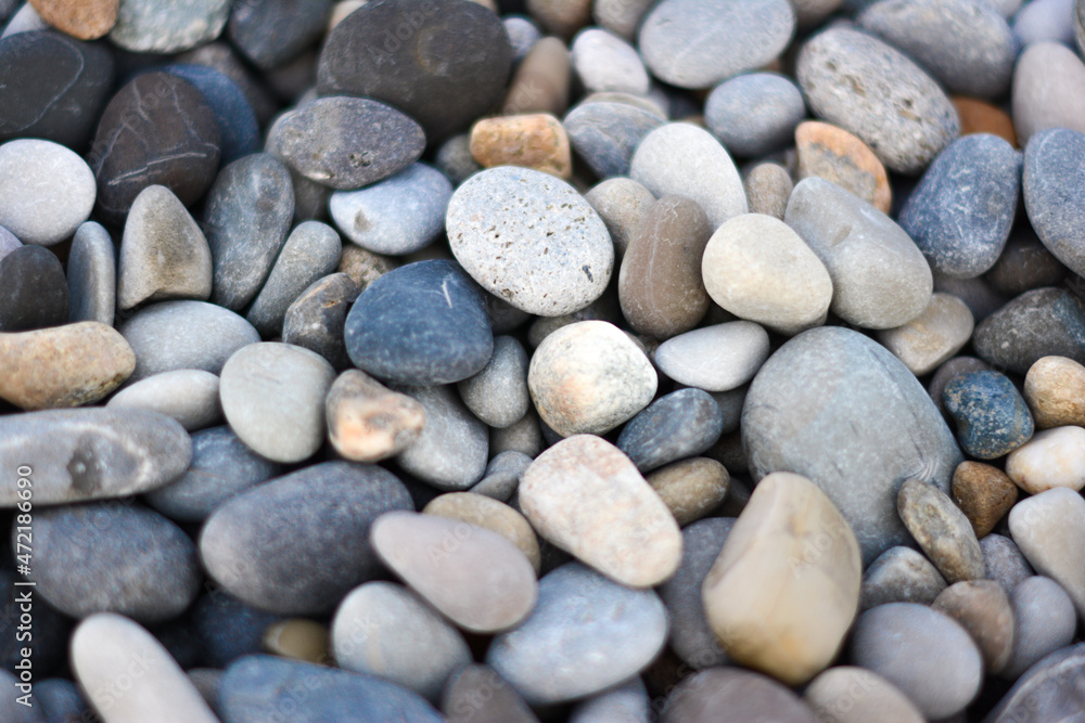 Abstract background with round pebble stones different colors. Stones beach smooth. Top view. Soft focus. Abstract background with round pebble stones different colors. Stones beach smooth. Top view. Soft focus.