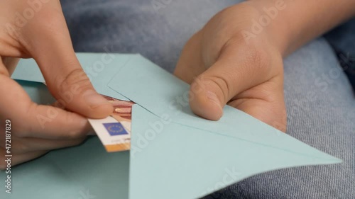 Teenage boyd hands open blue envelope, checking, counting a few cash Euro banknotes. Present gift, saving, financial literacy for children photo