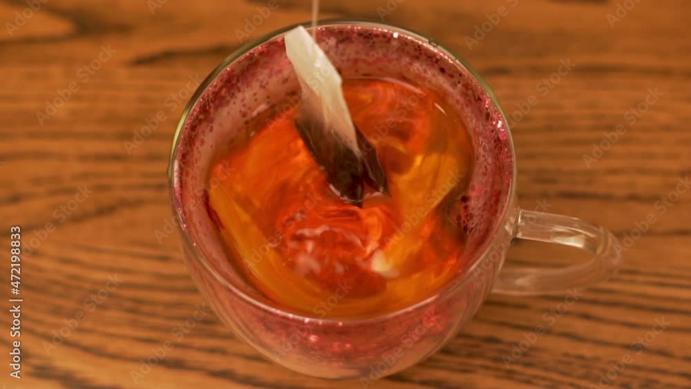 Morning Tea Drinking Concept. Brewing a Sachet of Fragrant Black Tea in a Cup on a Wooden Table, Close-up. Morning Tea Drinking Concept. Brewing a Sachet of Fragrant Black Tea in a Cup on a Wooden Table, Close-up.