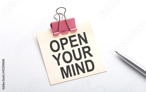 OPEN YOUR MIND text on the sticker with pen on the white background