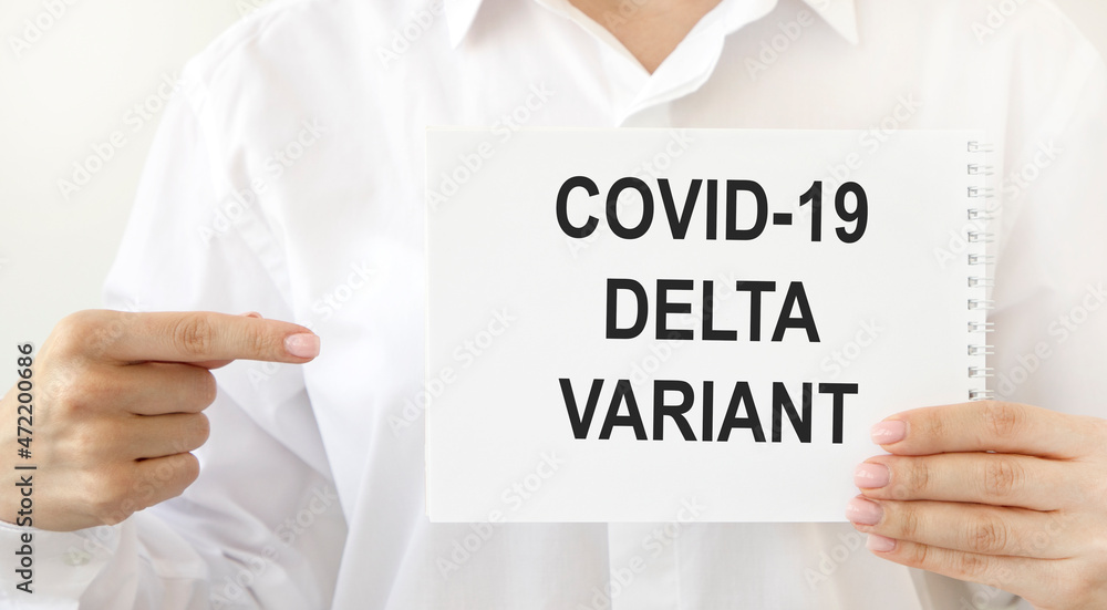The girl holds a notebook with the COVID-19 DELTA VARIANT test, pointing her finger at it. The girl holds a notebook with the COVID-19 DELTA VARIANT test, pointing her finger at it.