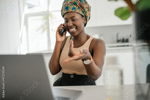 Black African traditional woman working from home wearing headscarf