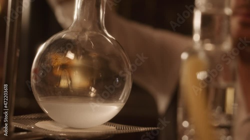 Alchemist pouring liquid into flask