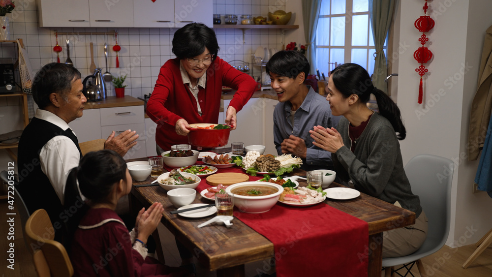 cheerful asian senior woman grandmother in red clothing putting thumb up while serving her specialty on table, feeling proud of her cooking. ready to have family reunion dinner on lunar new year - obrazy, fototapety, plakaty 
