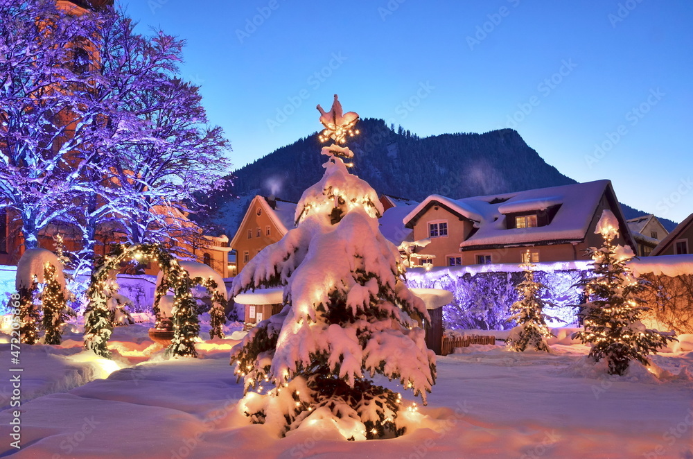 Alpen, Weihnachten in Altstadt mit Weihnachtsbaum, Lichter, Schnee am Abend