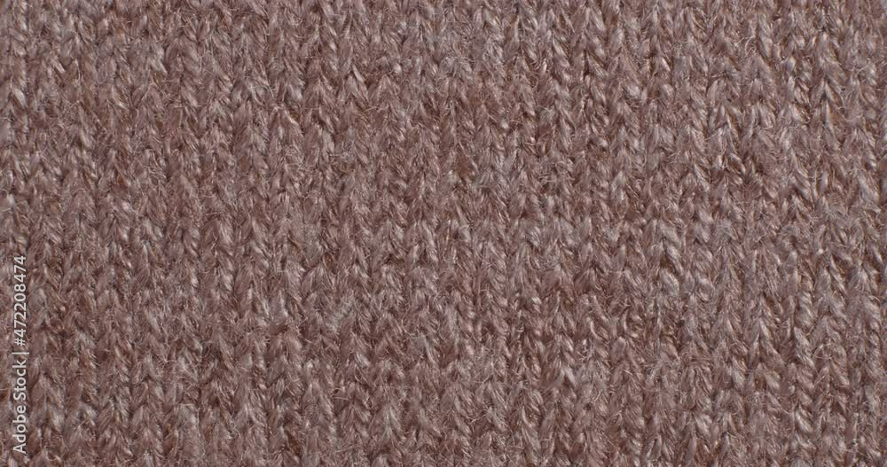 The texture of the knitted part is close-up. Macro fragment. Brown background. The texture of the knitted part is close-up. Macro fragment. Brown background.