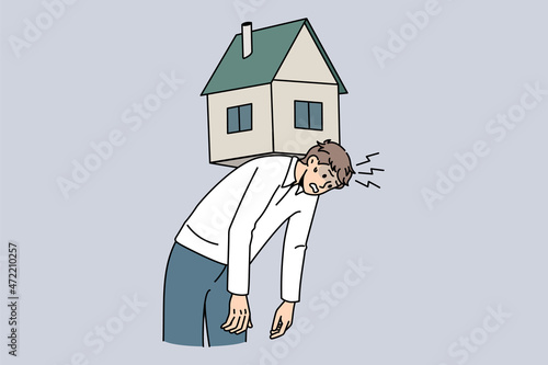 Exhausted young man carry house on back suffer from bank mortgage or lease burden. Tired male struggle with financial payment, home expenses, bills and taxes. Flat vector illustration.