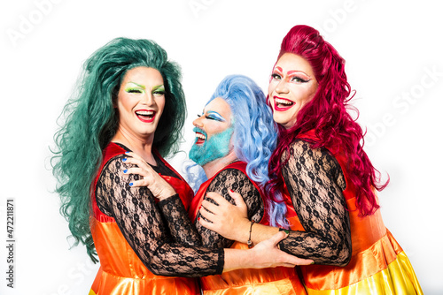 Cheerful drag queens with matching outfits against white background