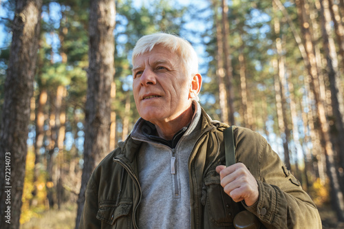 Senior male traveler with backpack in calm nature