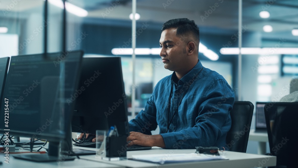 In Diverse Office: Portrait of Handsome Indian Man Working on Desktop Computer. Focused Professional Creates Innovative Software, Modern App Design. Stylish Multi-Ethnic Authentic Workplace In Diverse Office: Portrait of Handsome Indian Man Working on Desktop Computer. Focused Professional Creates Innovative Software, Modern App Design. Stylish Multi-Ethnic Authentic Workplace