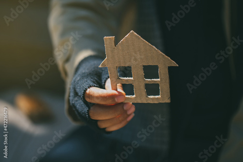 Bild auf Leinwand Poor tired depressed hungry homeless man holding a cardboard house
