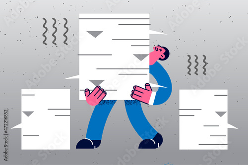 Exhausted businessman carry stack of paperwork documents