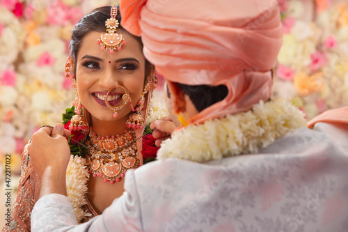 Indian groom tying mangal sutra around bride neck wedding ceremony photo