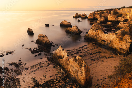 Beach rocks with golden light in Ponta Joao De Arens (Algarve, Portugal) photo