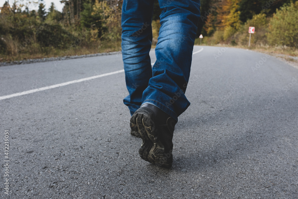 Man walking down on a forest road.
Man walking down on a forest road.