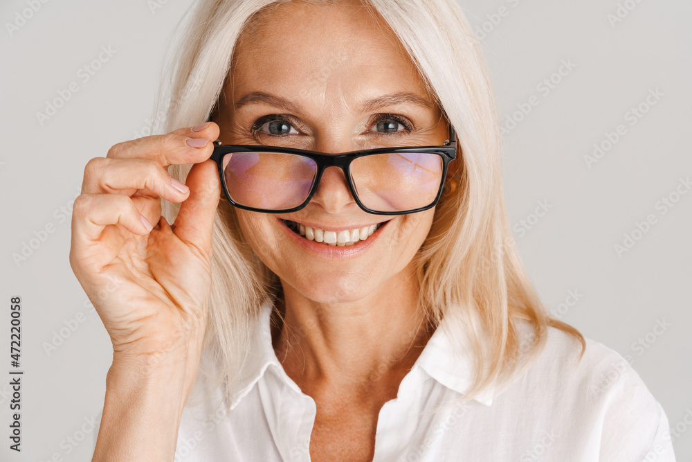 Mature woman in eyeglasses smiling and looking at camera Mature woman in eyeglasses smiling and looking at camera