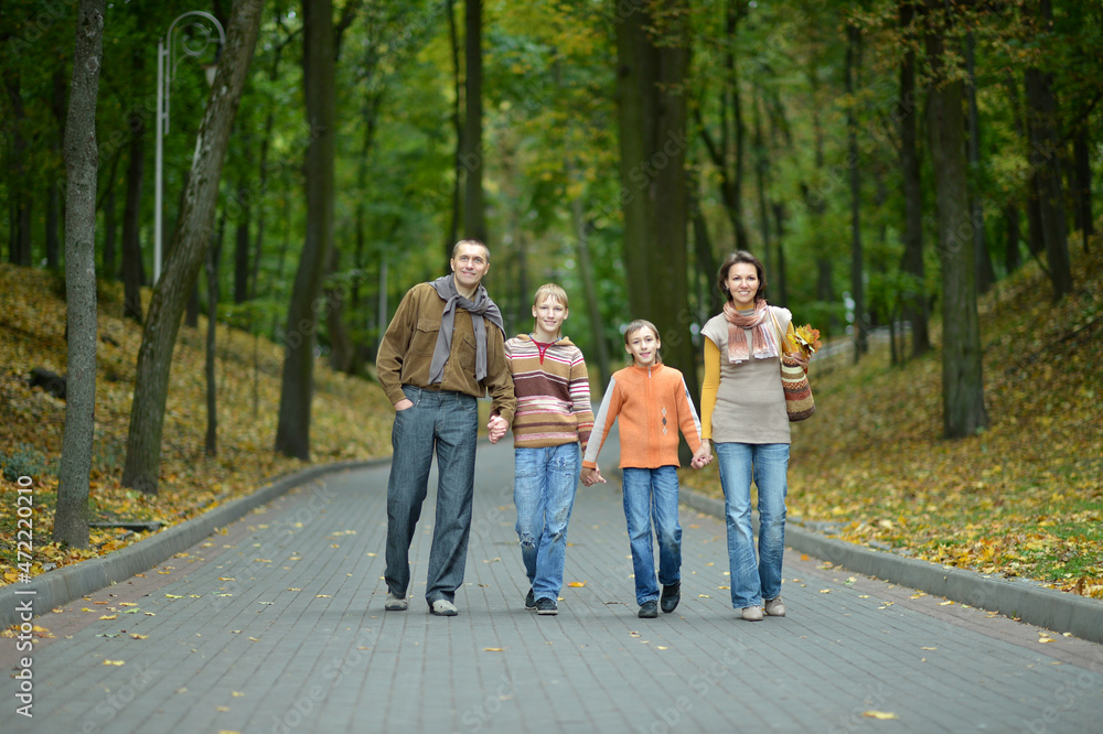 Family of four walking in autumn park Family of four walking in autumn park