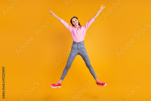 Full body photo of young lovely girl have fun jump up footwear active isolated over yellow color background