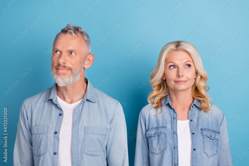 Photo of mature couple happy positive smile dream curious look empty space isolated over blue color background Photo of mature couple happy positive smile dream curious look empty space isolated over blue color background
