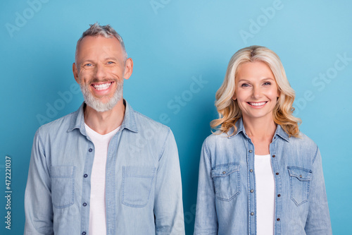 Photo of mature cheerful couple happy positive toothy smile veneers ceramic isolated over blue color background