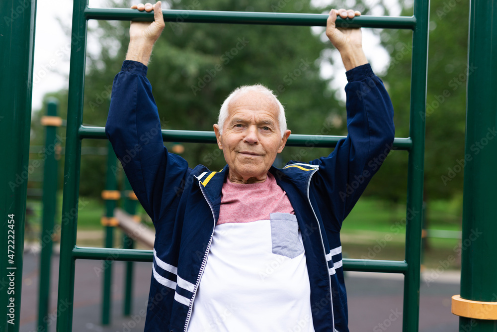 Naklejka premium Senior man training on vertical ladder outdoors