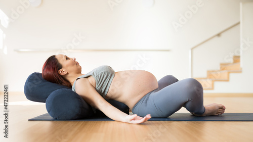 pregnant woman is engaged in yoga. Reclined Bound Angle Pose or Supta Baddha Konasana