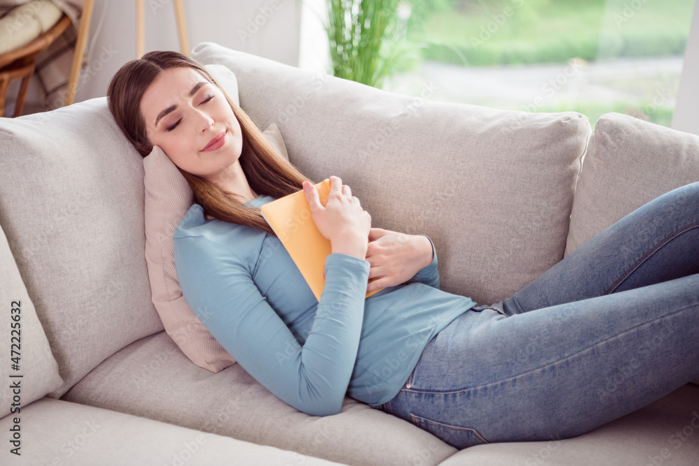 Photo portrait young woman sleeping on couch keeping book relaxing at home