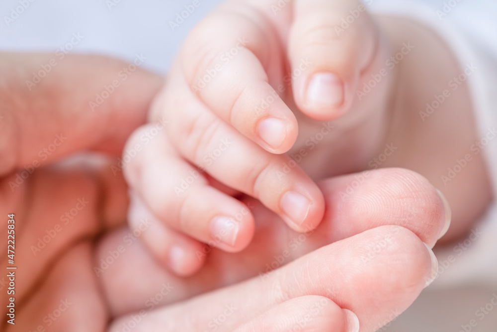 Newborn baby hand in mothre's hand. Macro view Newborn baby hand in mothre's hand. Macro view