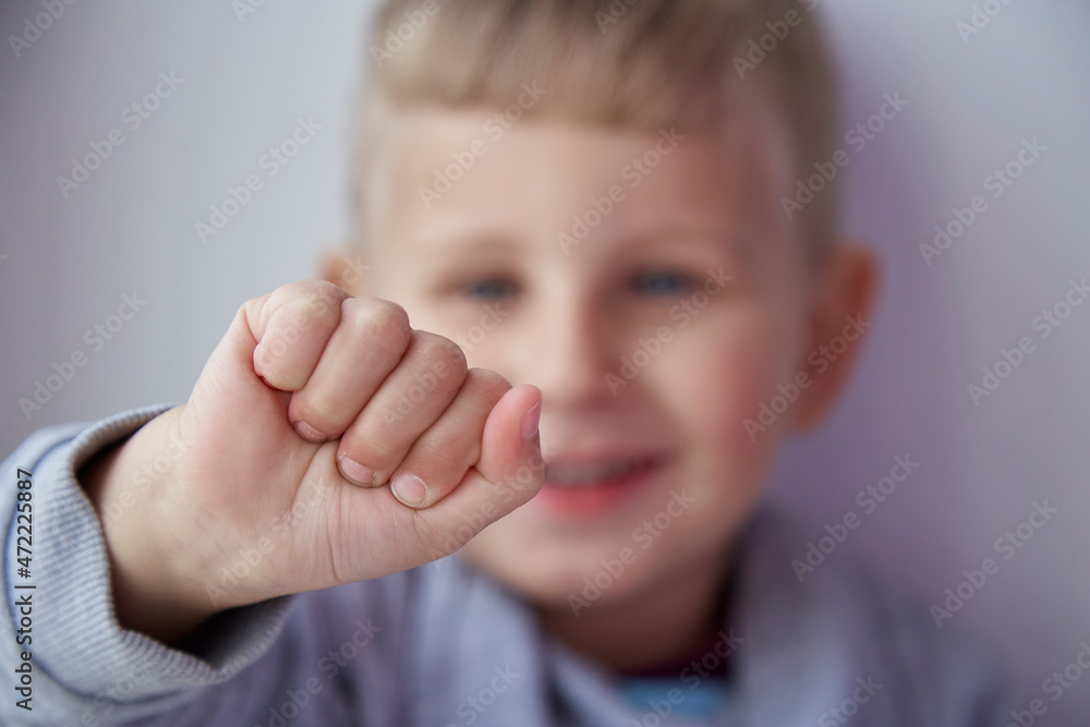 Cute smiling boy shows a cam in front of camera. Portrait of toddler close up. Selective focus Cute smiling boy shows a cam in front of camera. Portrait of toddler close up. Selective focus