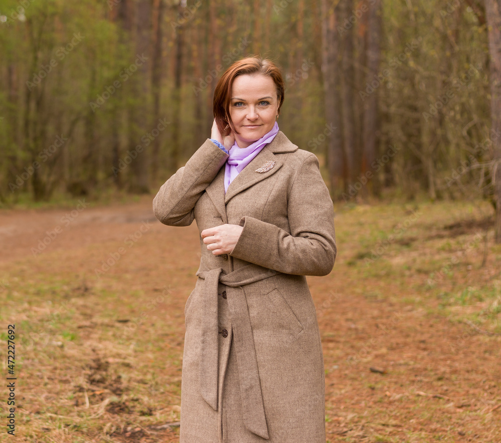 smiling woman in coat in spring in the forest smiling woman in coat in spring in the forest