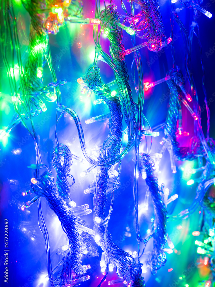 Fototapeta premium multicolored garland with small led bulbs on a dark background