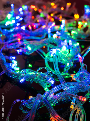 multicolored garland with small led bulbs on a dark background