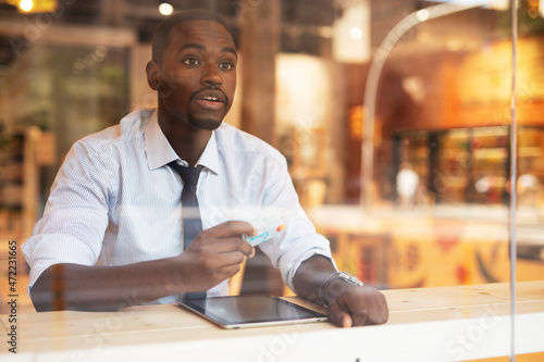 Businessman in cafe holding a credit card. Guy making online payment. Man paying the bill in cafe with a credit card.