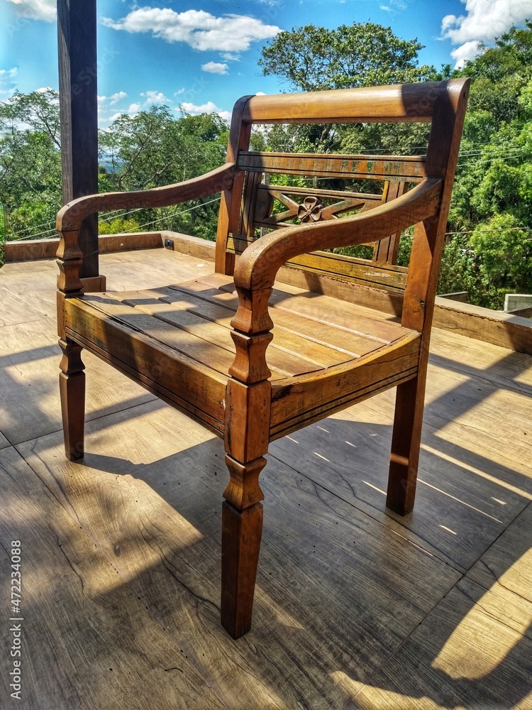 Wooden elegant chair on a deck with gorgeous view. Forniture for outdoor areas. Resistent, long lasting and fashionable look. Wooden elegant chair on a deck with gorgeous view. Forniture for outdoor areas. Resistent, long lasting and fashionable look.