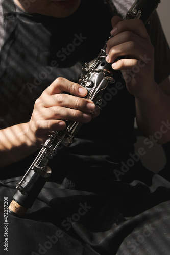 Unrecognizable man examining a clarinet body