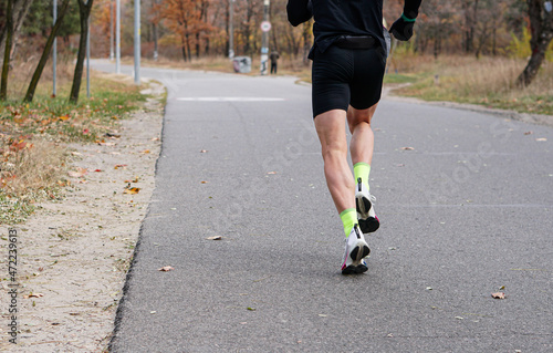 Fototapeta Naklejka Na Ścianę i Meble -  Morning run, man's legs while jogging, in autumn. Healthy Lifestyle.