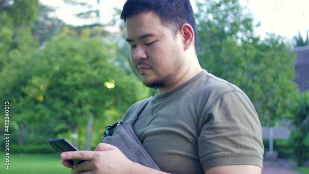 man while using mobile phone in the park in the city man while using mobile phone in the park in the city