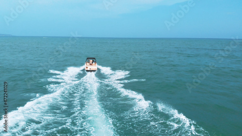 the speedboat is moving towards the horizon at high speed, making waves at sea. High-quality photo