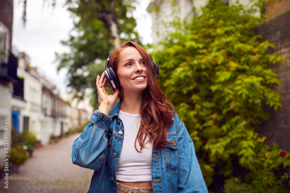 Female Vlogger Or Social Influencer Wearing Headphones Travelling Through City Female Vlogger Or Social Influencer Wearing Headphones Travelling Through City