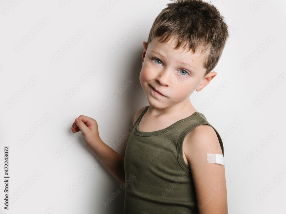 Schoolboy after vaccination with band aid on arm