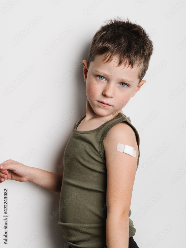 Schoolboy after vaccination with band aid on arm Schoolboy after vaccination with band aid on arm
