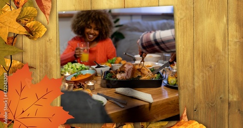Composite image of people having delicious food at thanksgiving party and autumn leaves, copy space