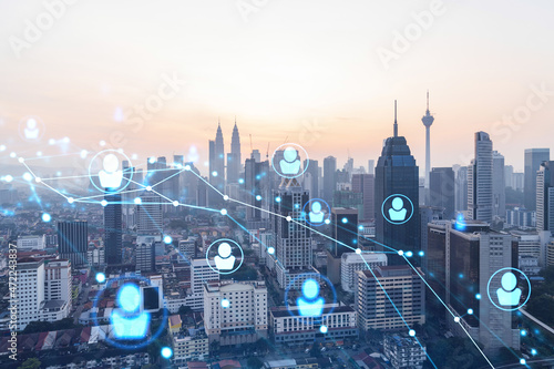 Photography Hologram of social media icons over sunset panoramic cityscape of Kuala Lumpur, Malaysia, Asia